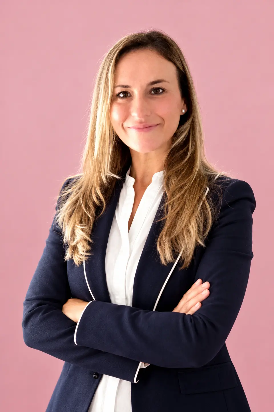 Cristina Ruiz sonríe con los brazos cruzados, con blazer azul marino y blusa blanca